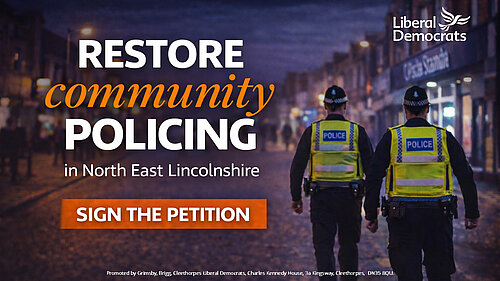 Two police officers walking on patrol in a town centre street at dusk, with text reading “Restore community policing in North East Lincolnshire” and “Sign the petition”.