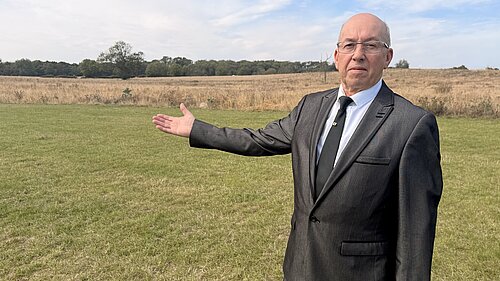 Brian Barrett gestures towards the open land beside Weelsby Woods identified for a proposed development of up to 1,500 homes.
