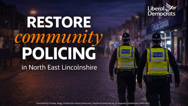 Two police officers walking on a street at night with the words “Restore Community Policing in North East Lincolnshire.